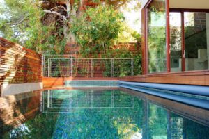 Seamless indoor-outdoor luxury living space with vanishing doors and custom pool